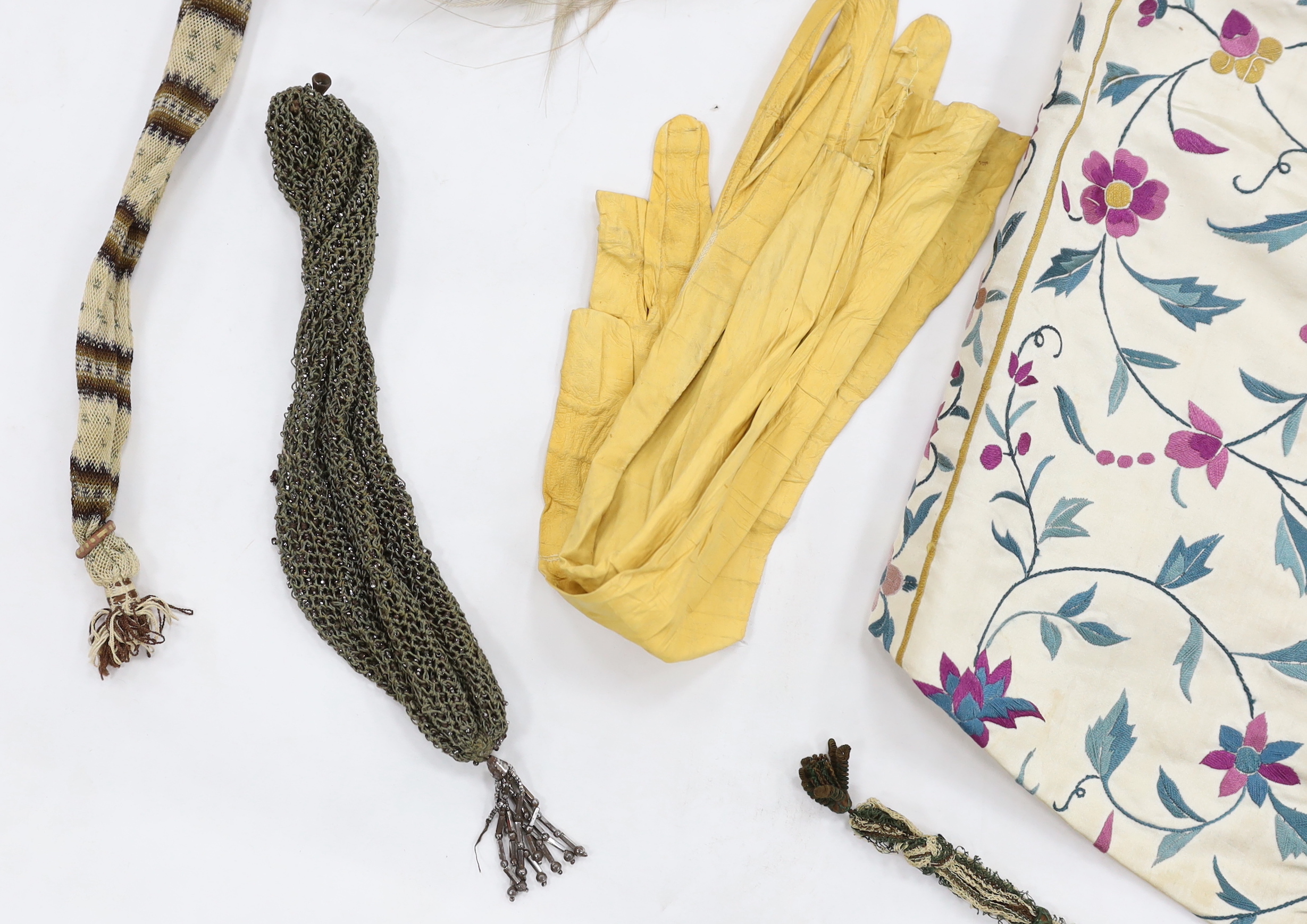 A collection of eight late 18th / early 19th century cut steel and other misers purses, a pair of yellow Regency ladies long shami leather gloves, an exotic feather hat ornament and a Chinese embroidered young boys waist